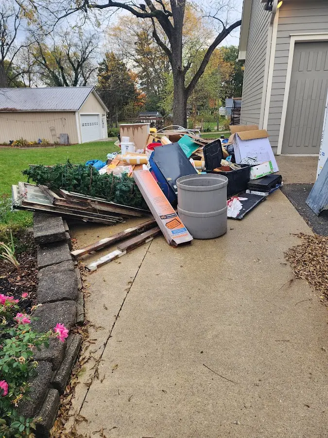 Dumpster being loaded with debris for Commercial Dumpster Rental in Oscoda